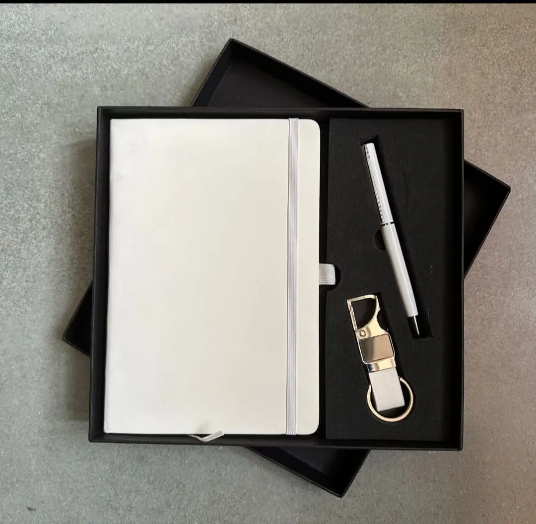 White notebook, silver pen and keychain in a presentation gift box